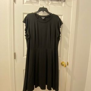 Black dress, arms has a flare style to it.